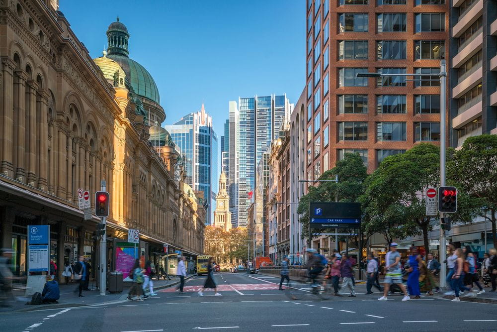 A busy street in the central business district of Sydney with office buildings all around.