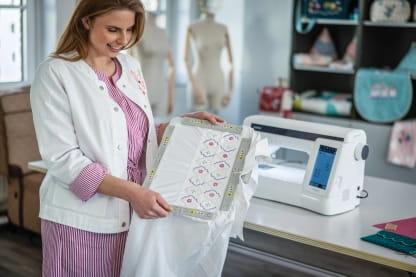 Image of a person holding the optional magnetic frame for the Brother Expedition BX1e Embroidery machine