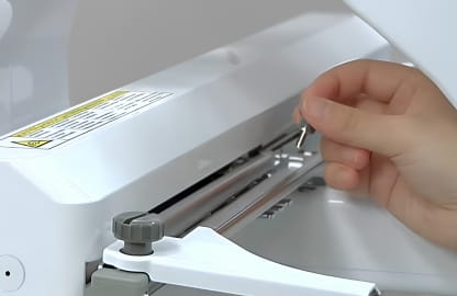 image of a person preparing to attached a Frame or Drive to a Brother Multineedle embroidery machine.r 