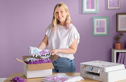 Image of a lady packing a box with T-Shirts that have been printed with the Brother Sublimation SP1 printer