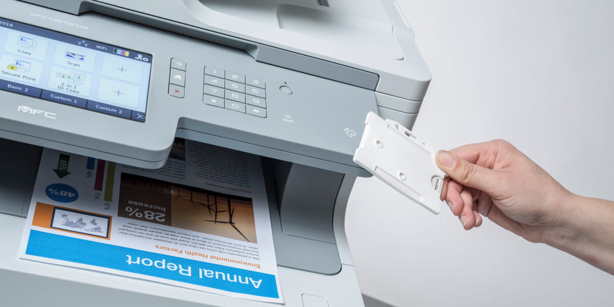 A person with an NFC card releasing a print job on a Brother multi-function laser printer