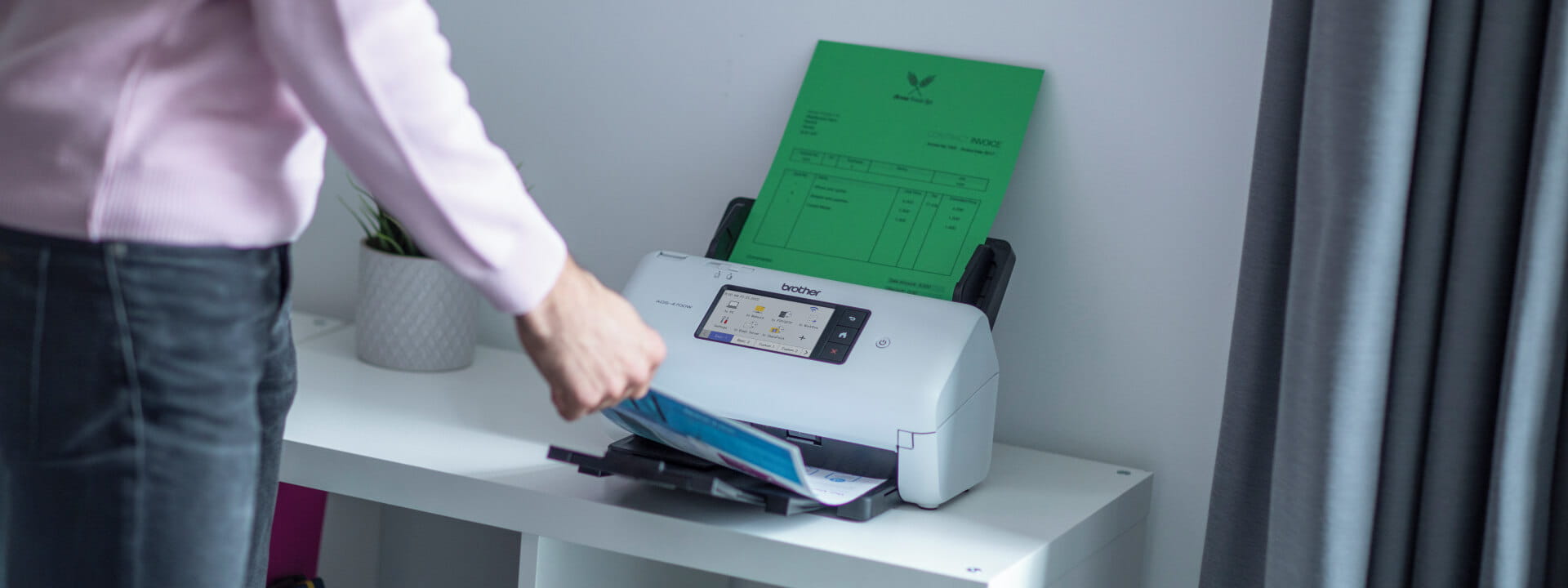 An office worker scanning documents through a Brother scanner.