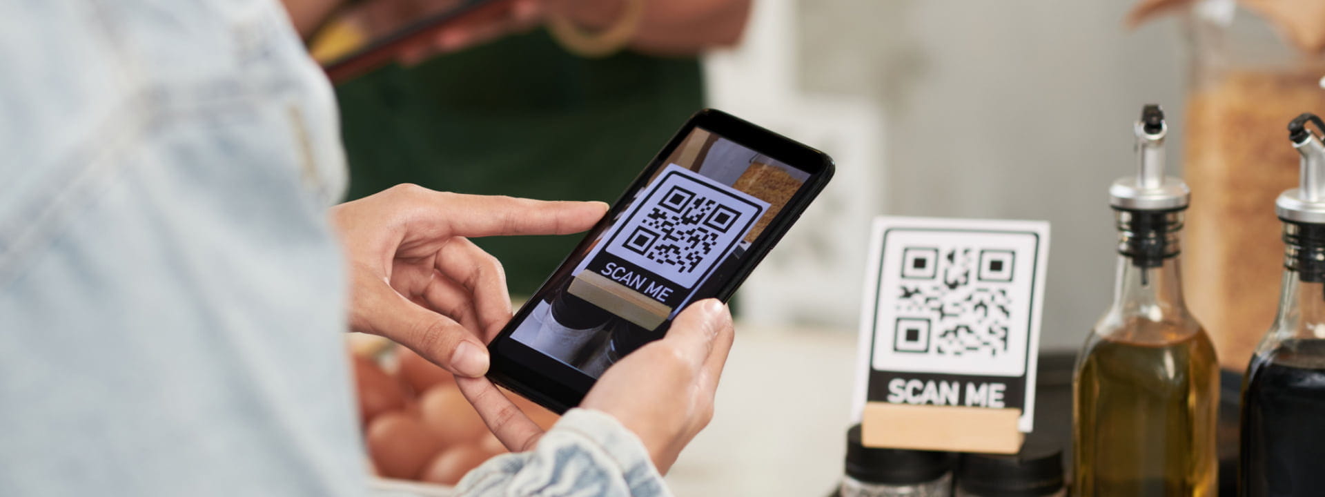 A person scanning a QR code with a smartphone in a restaurant