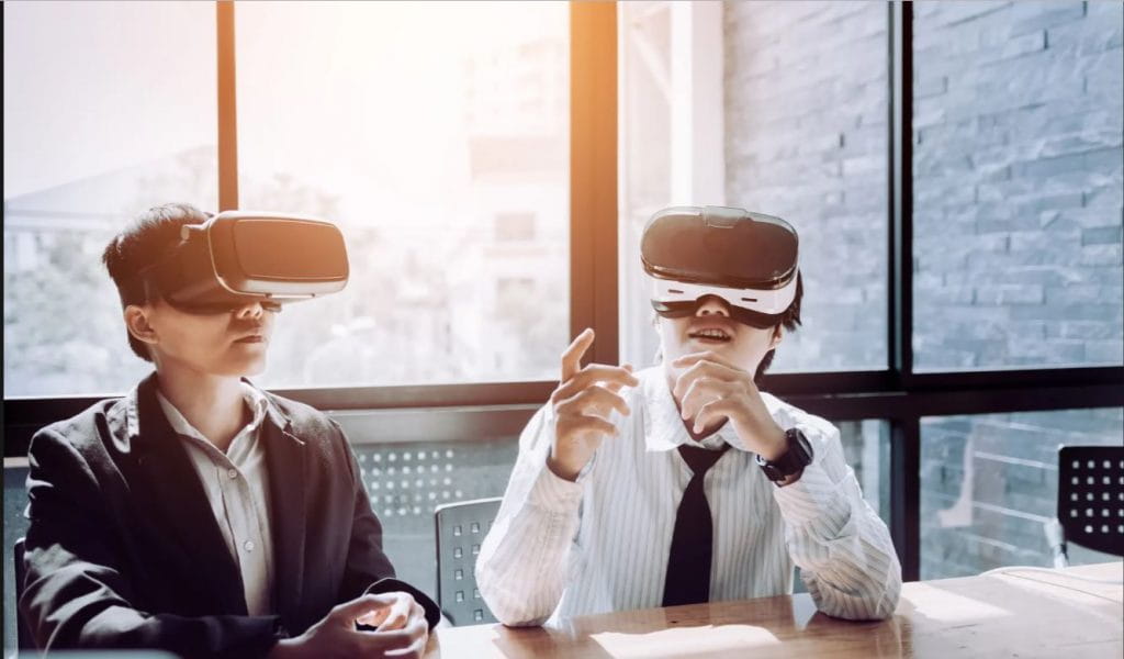 Two office workers with VR headsets on in a professional setting