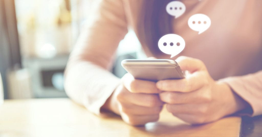 A person holding a smartphone with text boxed around it. 