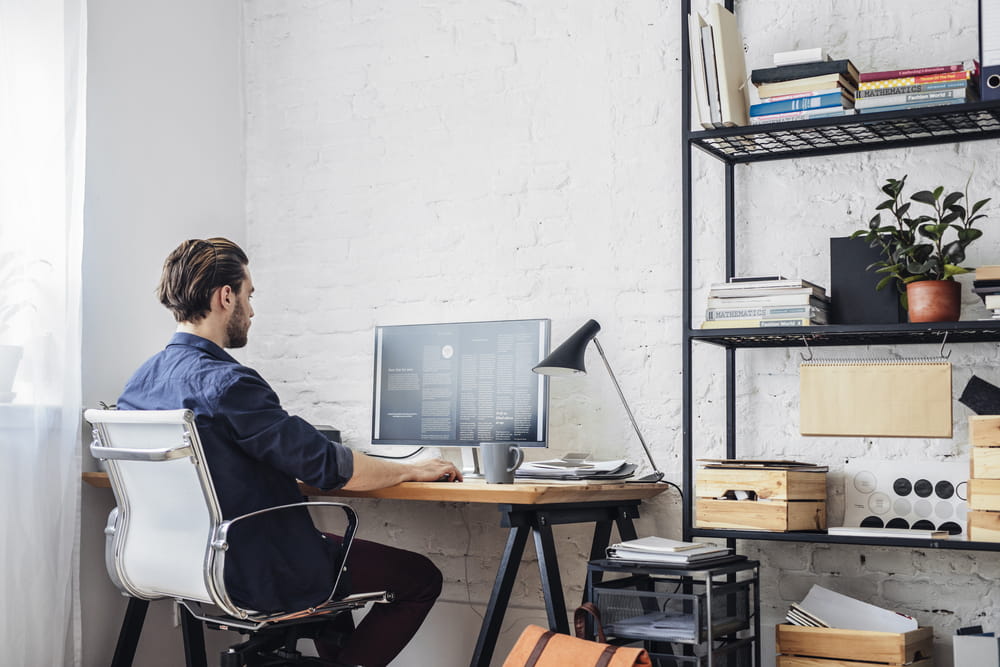 A man working from home on his computer in his study nook.