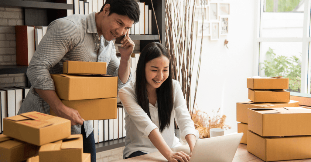 Man on phone with parcels next to woman on a laptop depicting a small business