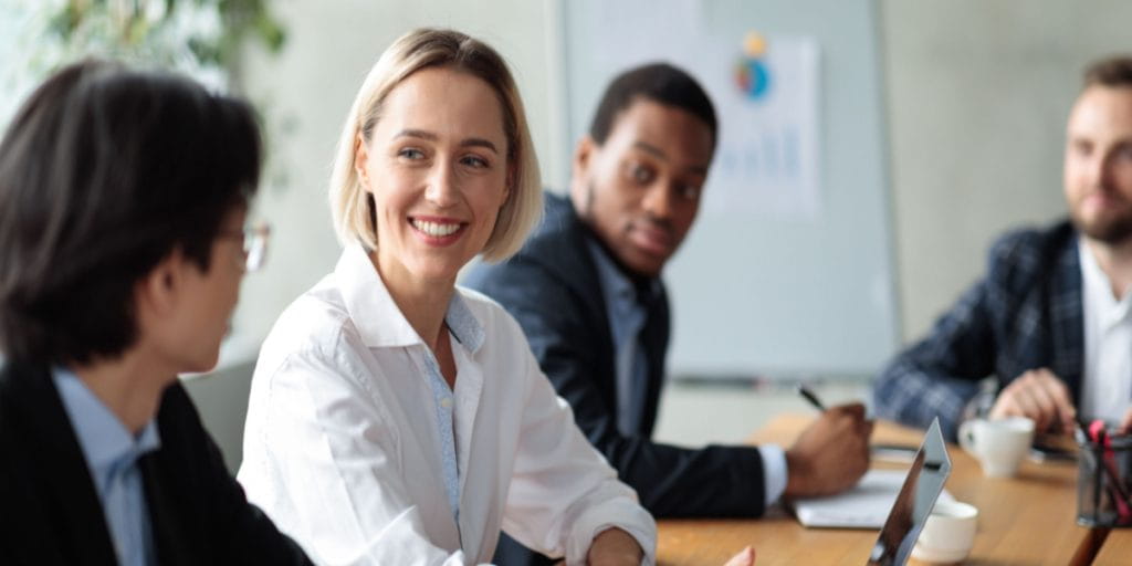 Lady entrepreneur sitting down with clients in a business setting