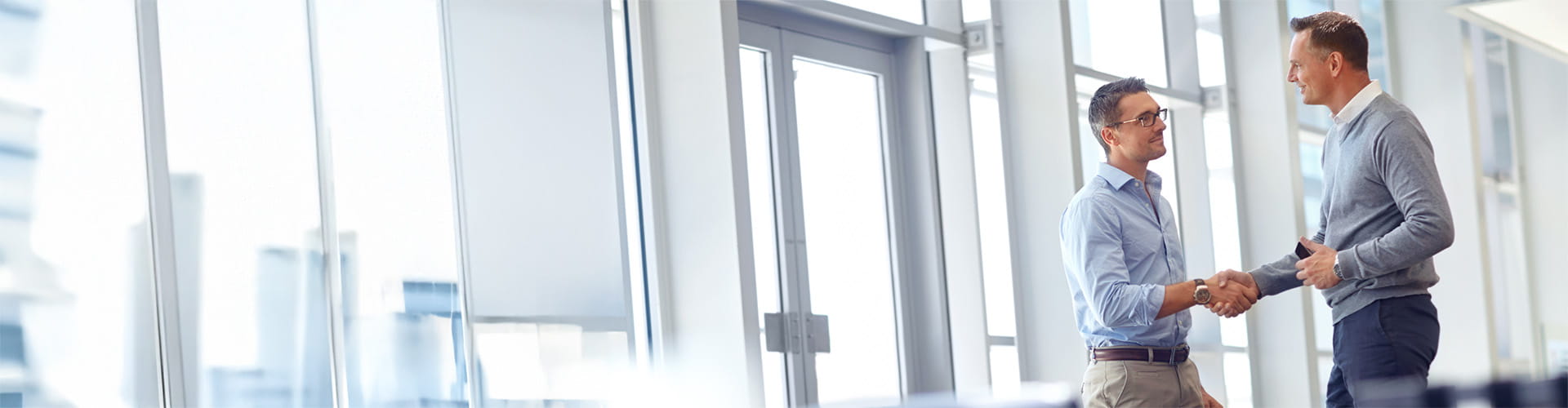 Two male employees shaking hands