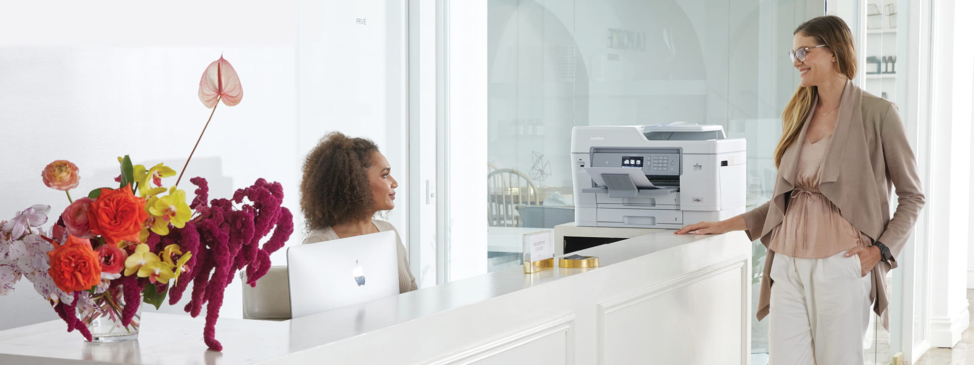 Receptionist chatting with a client with brother printer in the background