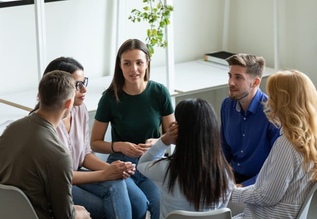 A group of people sitting around in a discussion