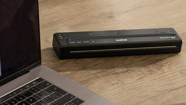The Brother PJ-863 Portable Printer next to a laptop on a desk