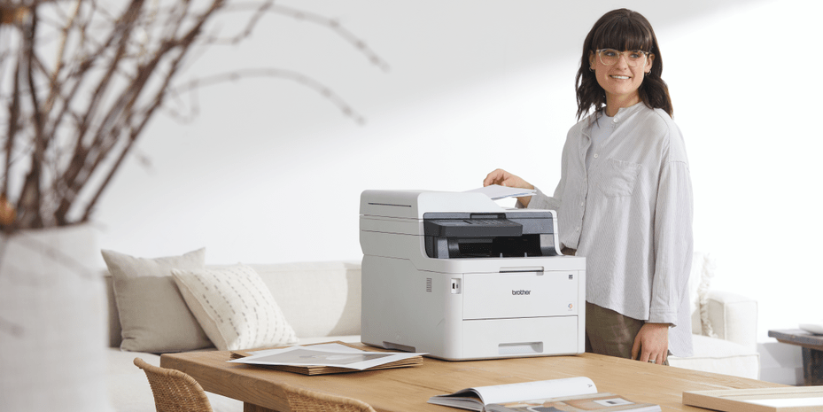 Lady standing next to a Brother Multi-Function Centre scanning documents in her home office
