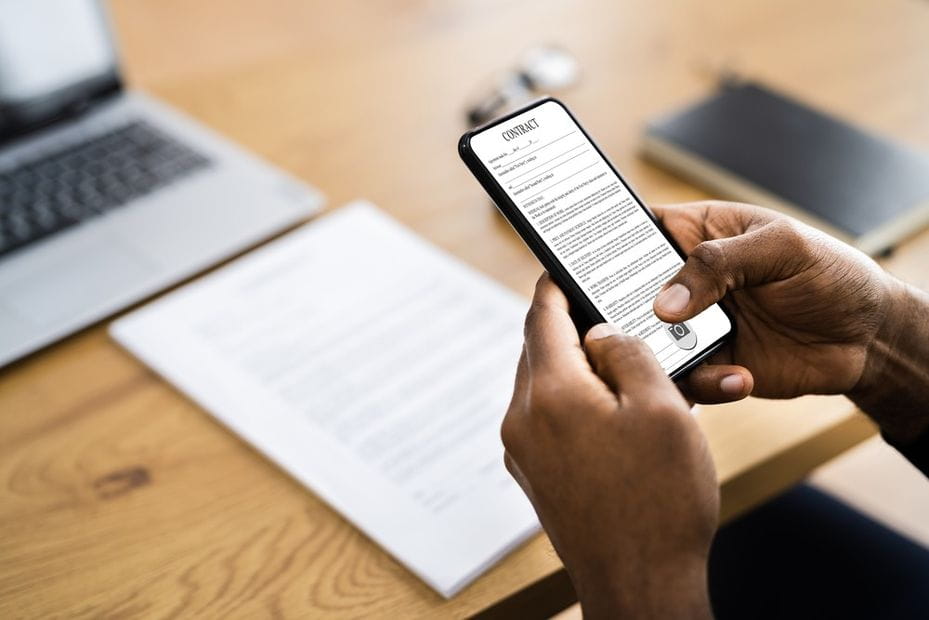 Man scanning a document with a smartphone at his desk