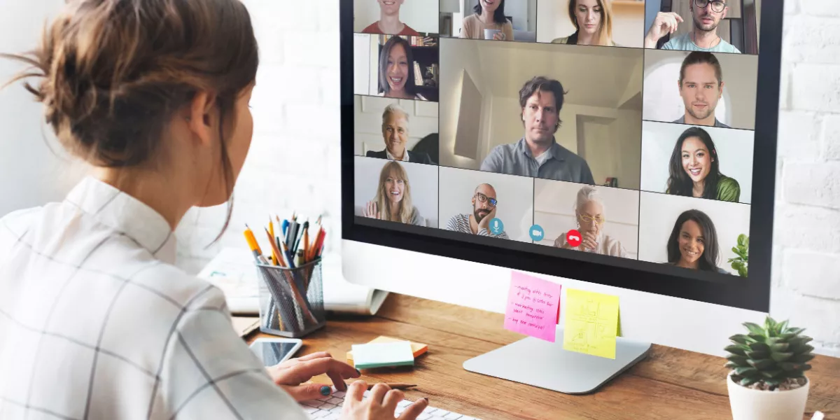 Female remote worker on team call with colleagues on laptop