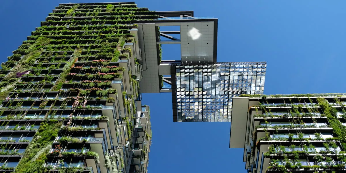A high-rise building with greenery on the outside of the walls