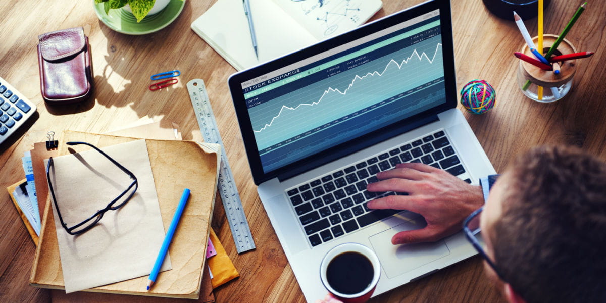 An eCommerce business owner on a laptop in a home office with stationary on the desk.