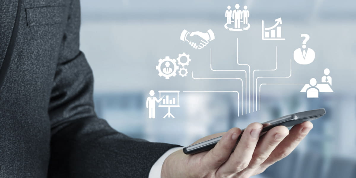 Person holding a smartphone with digital depiction of HR tools and tech