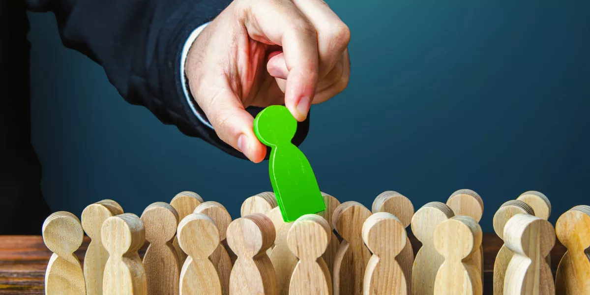 A hand pulling a green icon out of a bunch of non-coloured icons