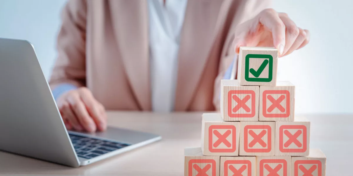 A HR professional placing a box with a tick on top of multiples boxes with crosses