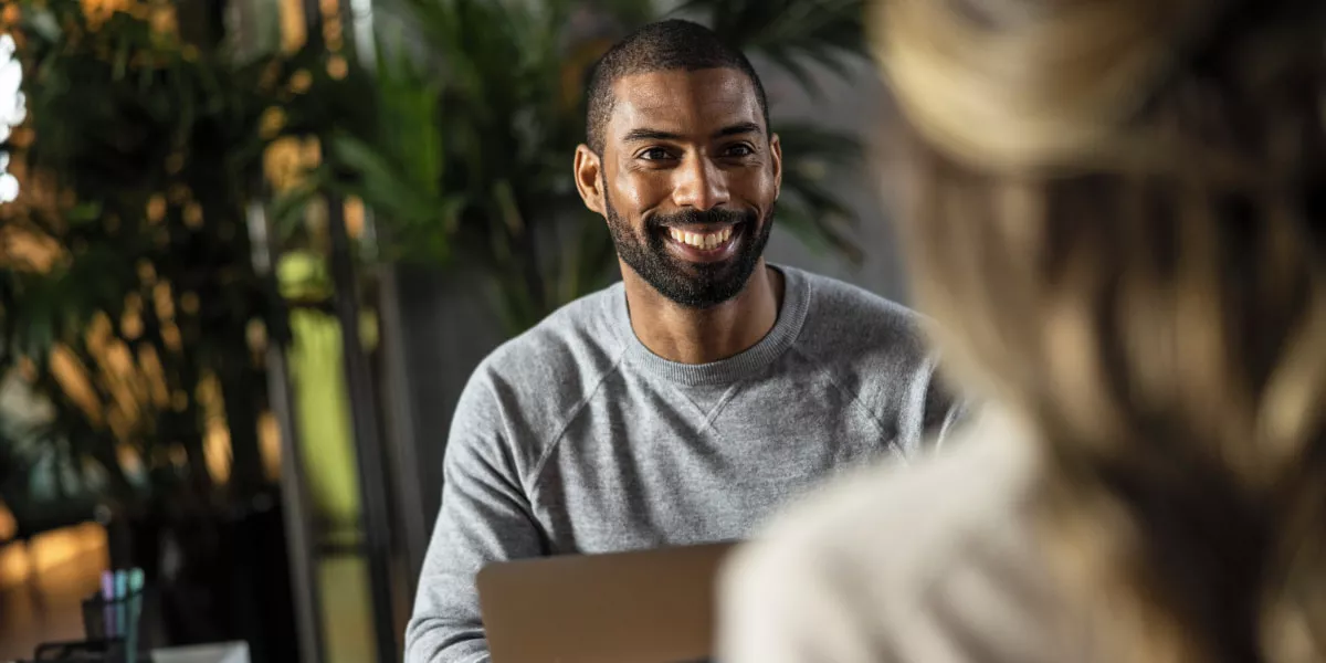 A male and female employee talking over a boardroom