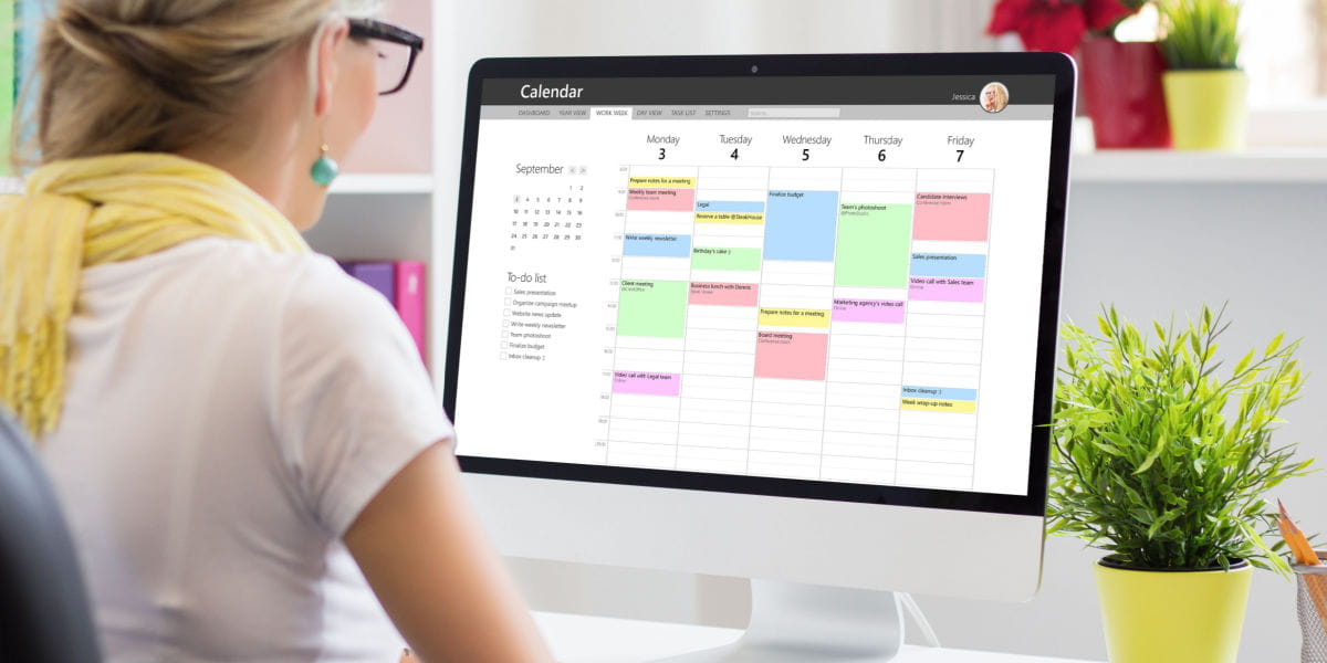 A lady freelancer looking at a work calendar on a computer screen 