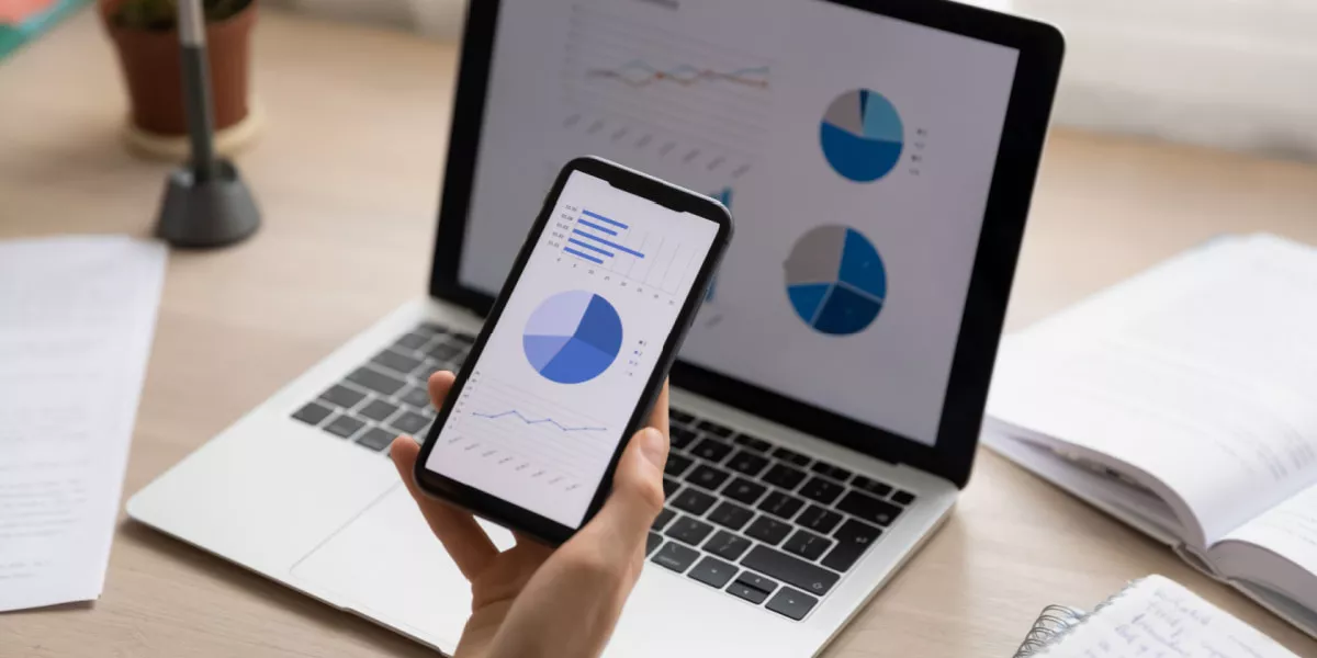 Graphs on a smartphone and laptop displaying online shopping trends 