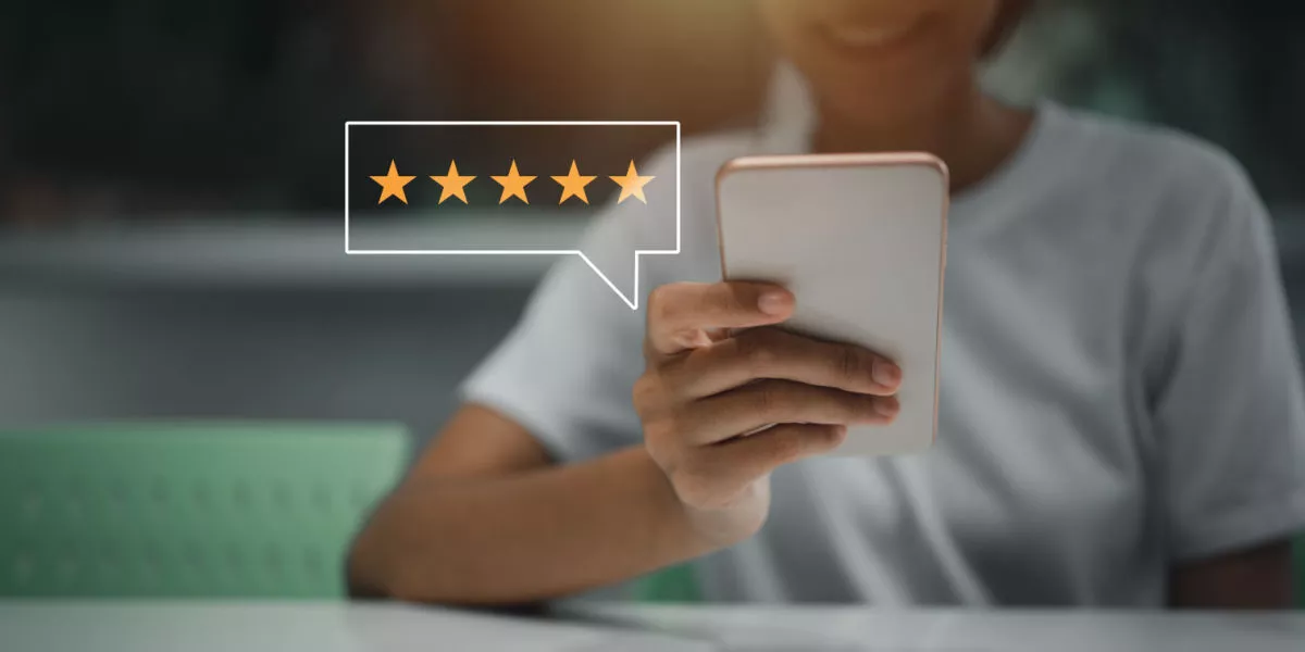 Person holding smartphone with stars visible depicting consumer reviews