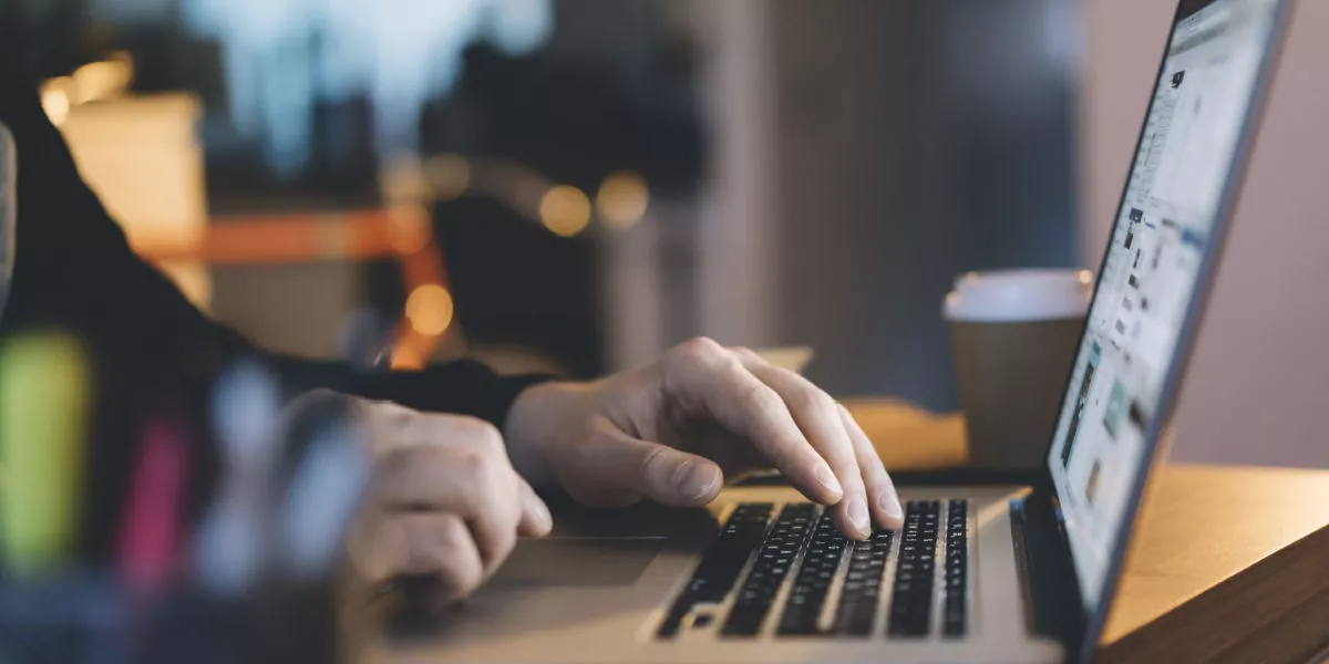 Man's hands typing up close on laptop