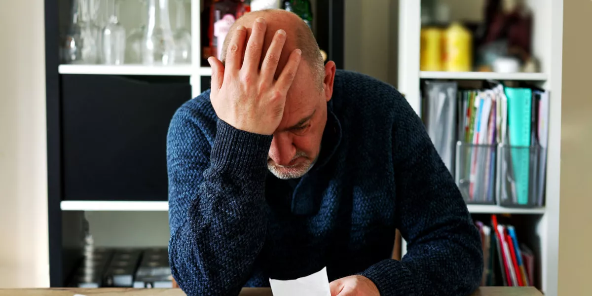 A man with his hand on his hand under a lot of financial stress