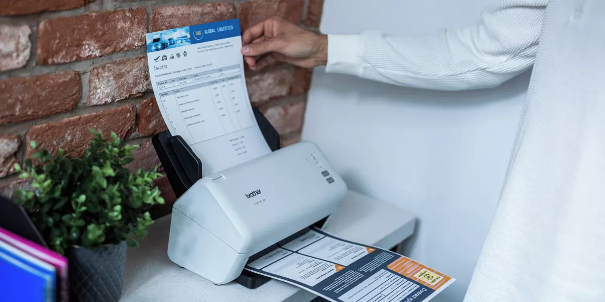 A person loading paper into a document scanner