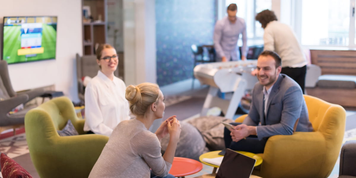 A group of colleagues sitting down happily in a meeting room