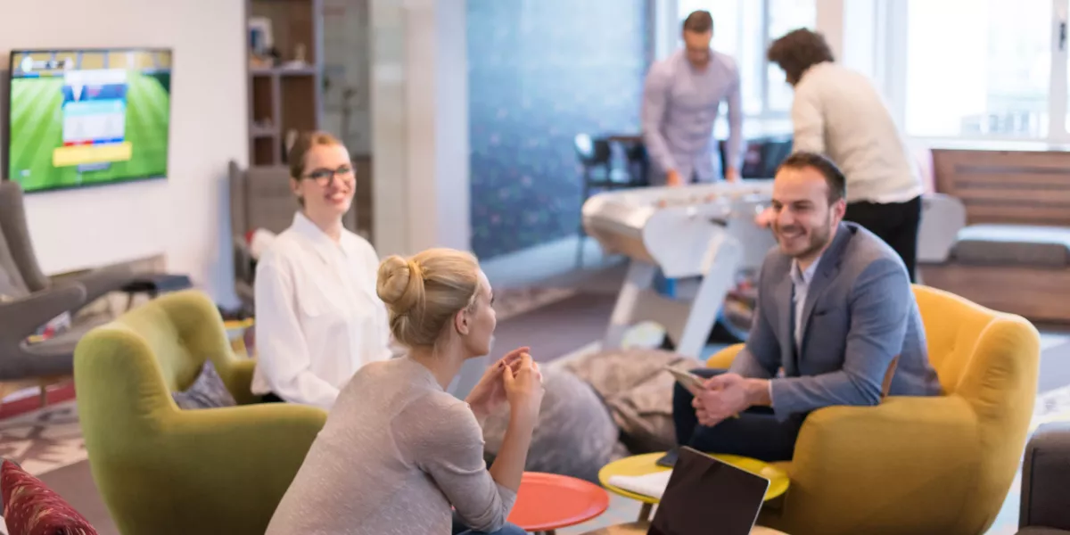 A group of colleagues sitting down happily in a meeting room