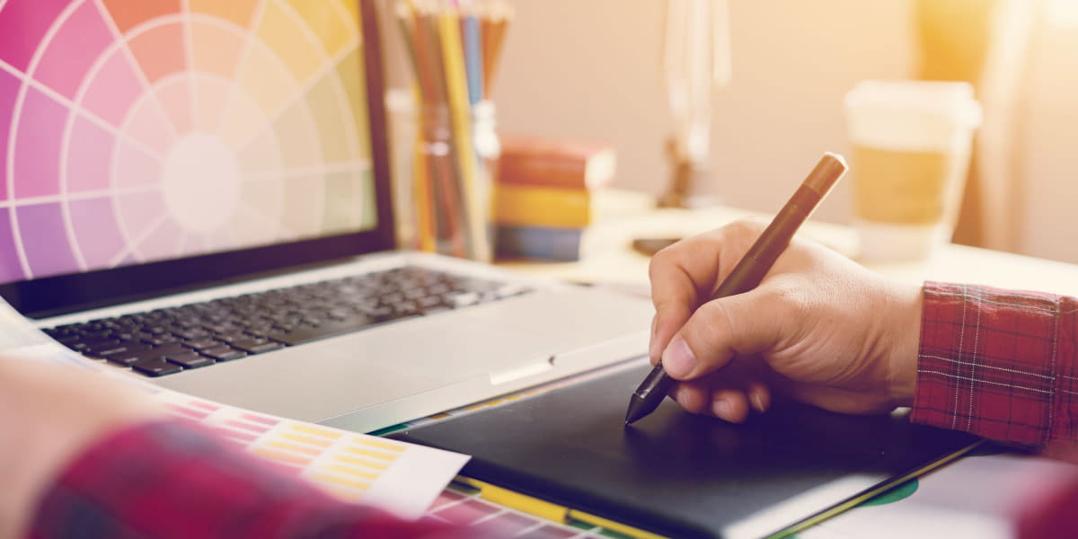 Person writing down brand details in front of a laptop