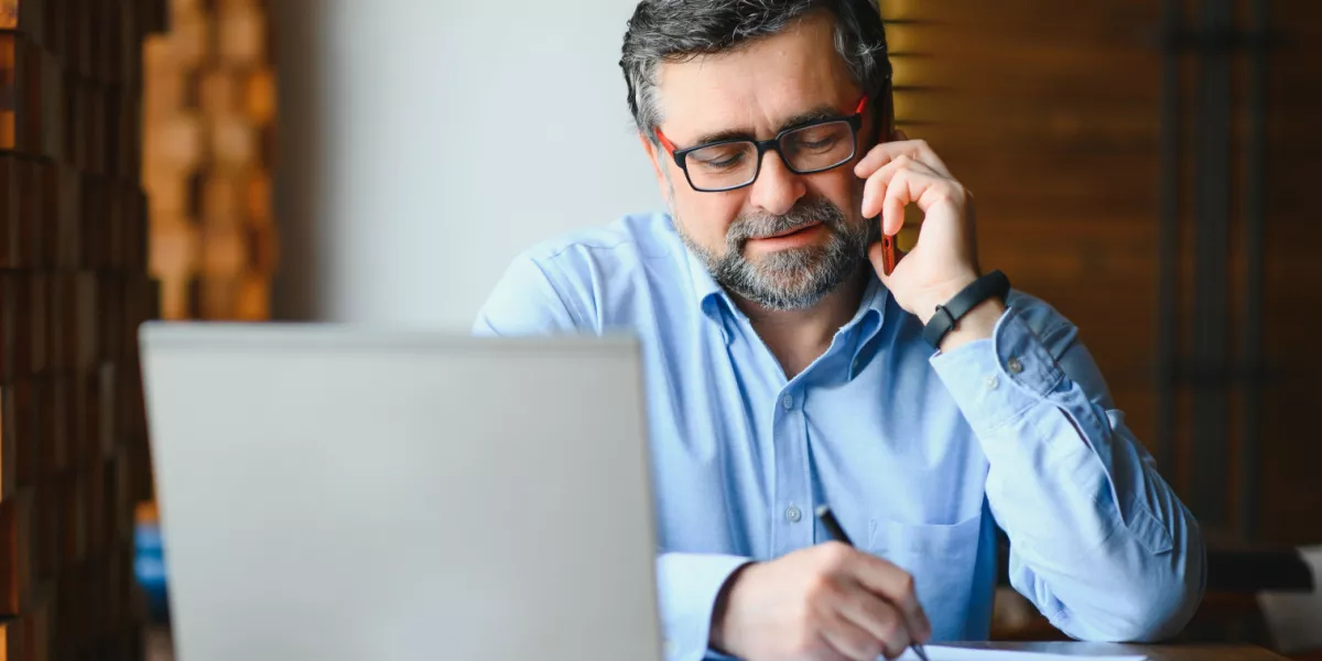 Business consultant on the phone in front of laptop in an offsite location