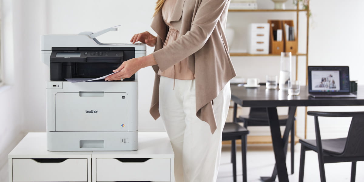 A Brother multi-function printer MFC-L8900CDW with a lady printing in office