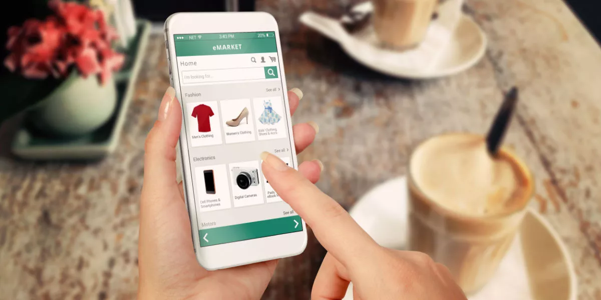 A person shopping on a smartphone in a cafe