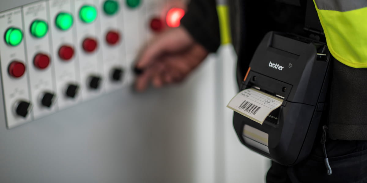 A technician printing a barcode with a portable label printer 