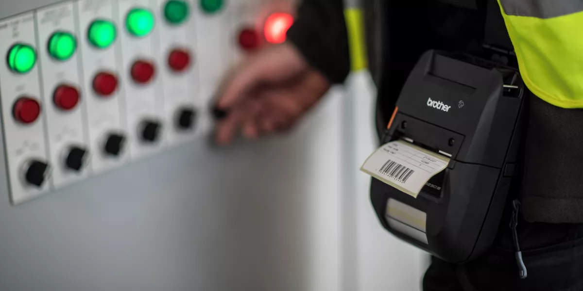 A technician printing a barcode with a portable label printer 