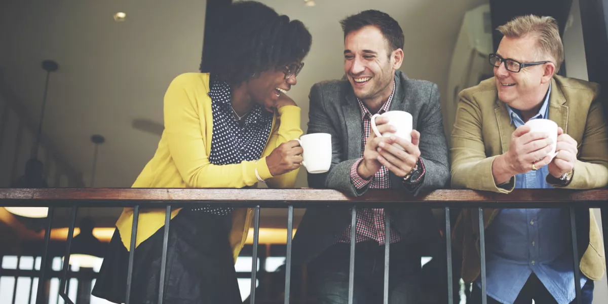 Three employees grabbing a coffee and talking