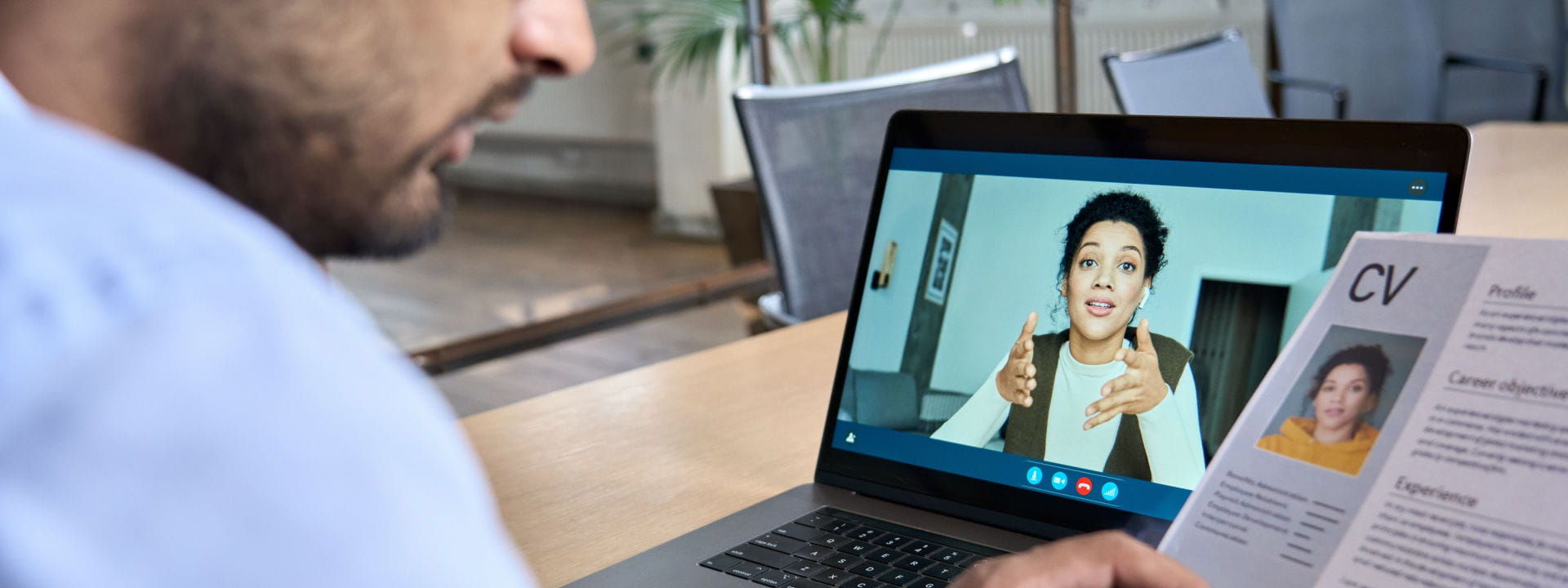 Man looking at CV with candidate on laptop screen during a virtual job interview