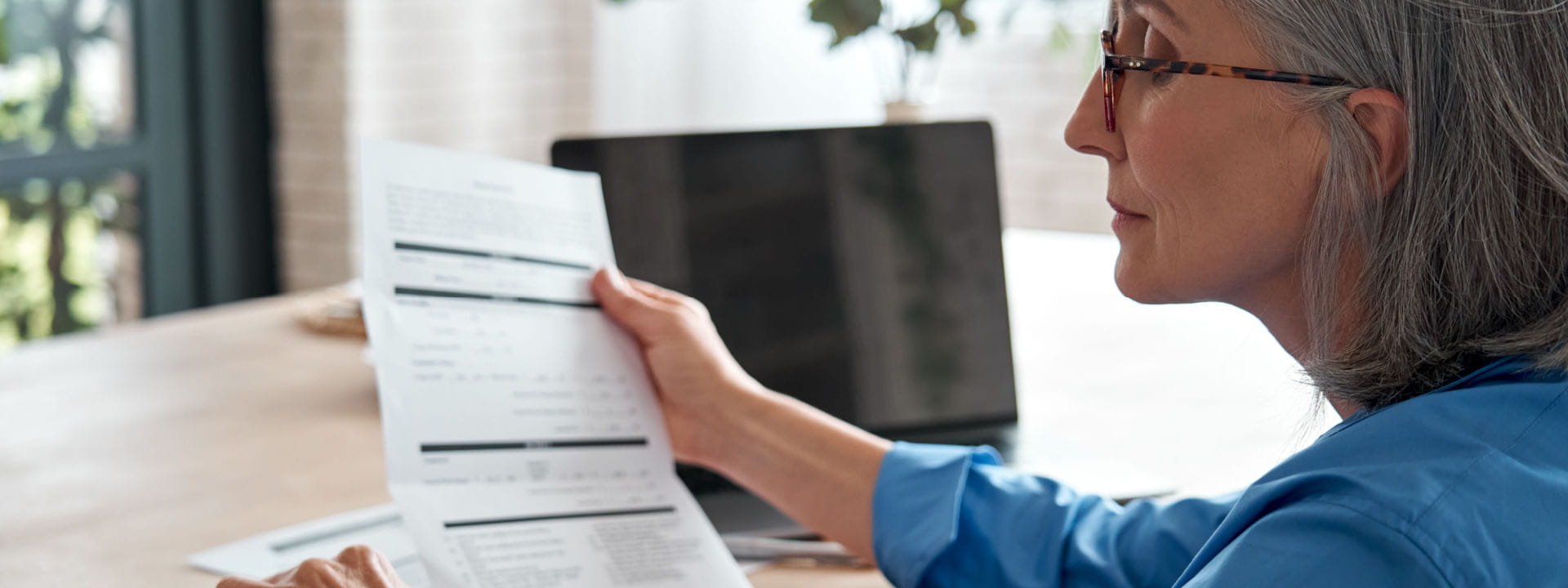 Lady working from home looking at an invoice to see if it's tax deductible