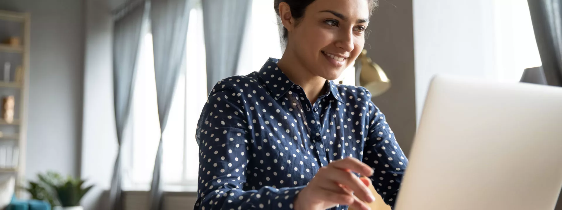 A female freelancer working on a laptop in a home setting
