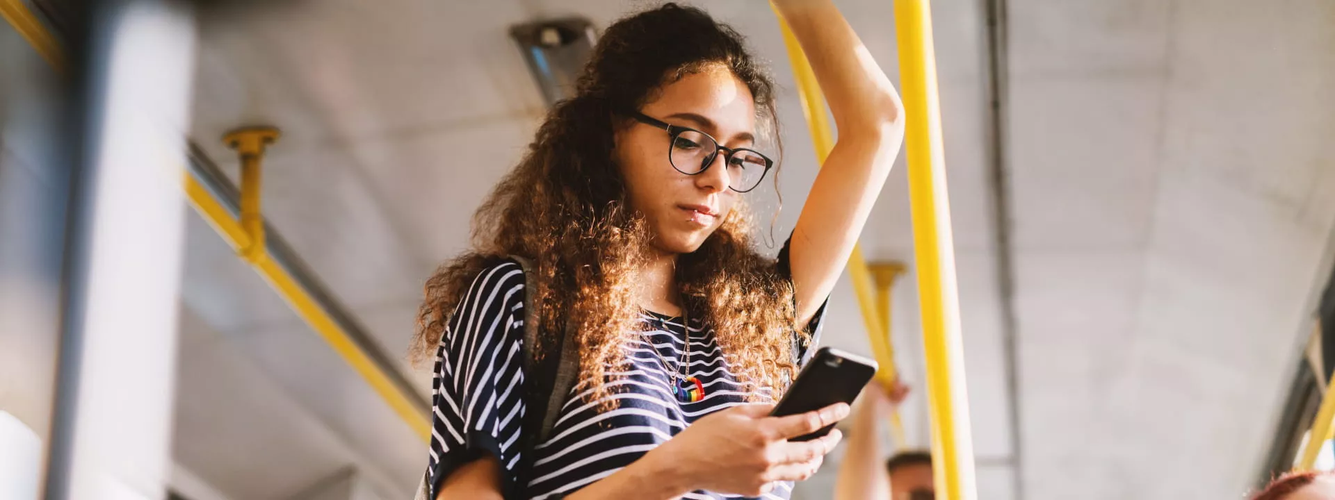 A young lady on her smartphone commuting to work via a bus