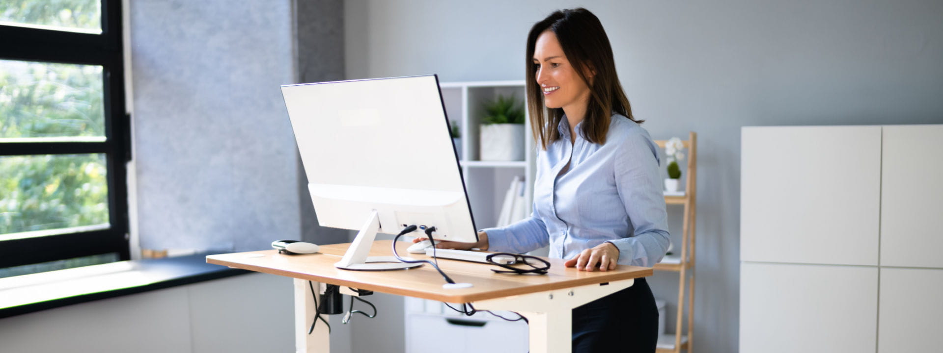 Lady working from home at her stand-up desk showing good ergonomics