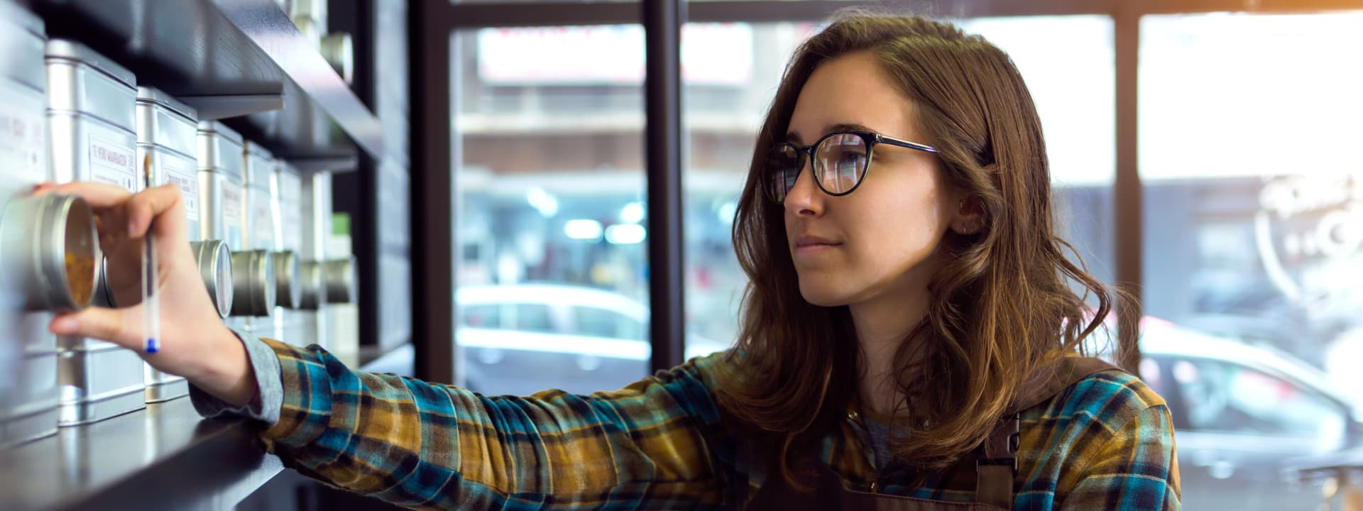 Retail business owner counting stock at a store front