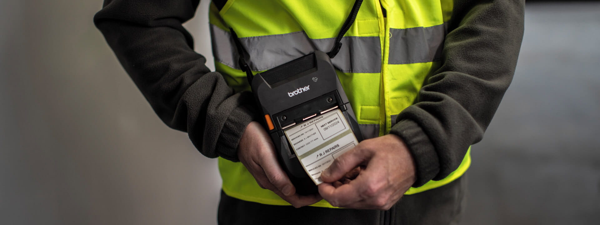 A technician printing a service label with a portable printer.