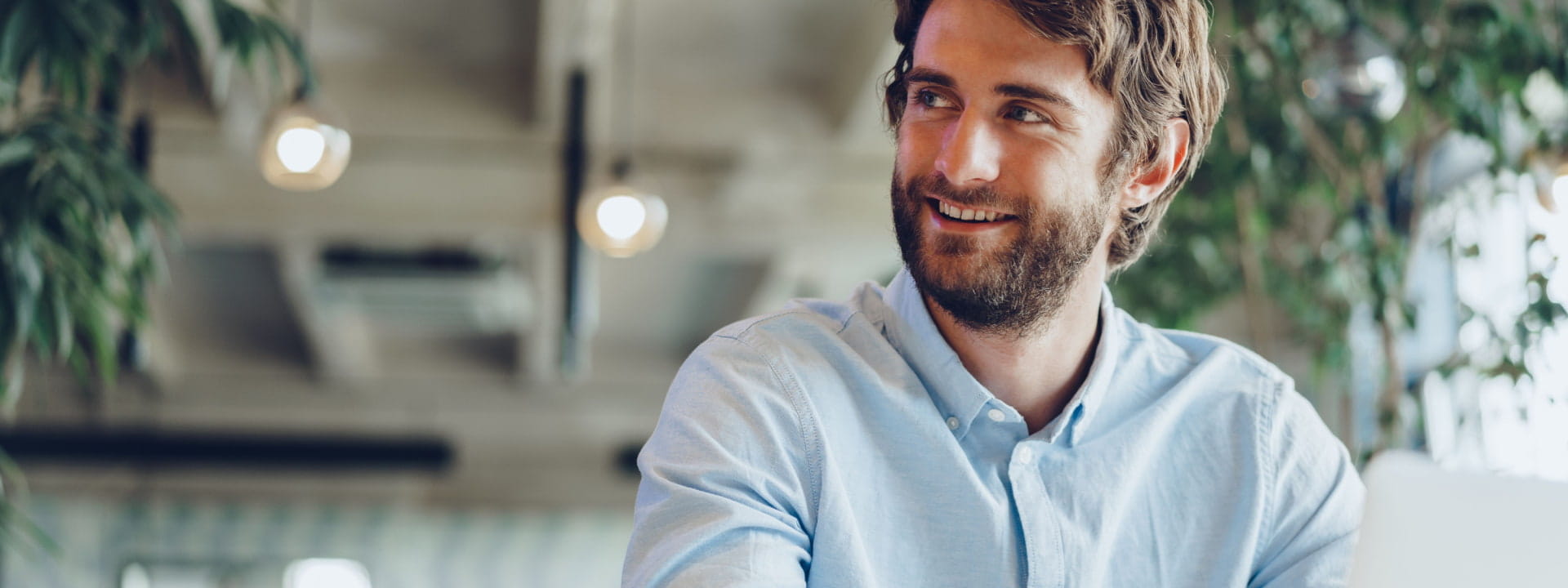 Young male business owner on a laptop in a cafe setting