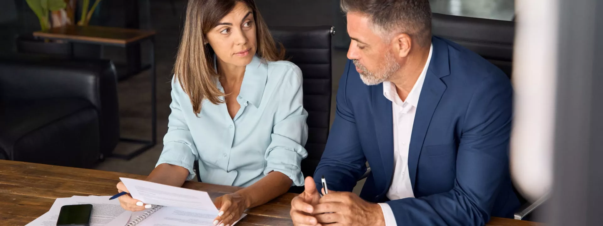 Two consultants reading printed documents in an office