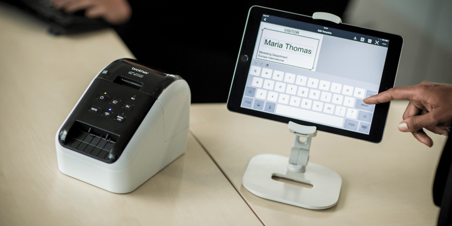 A visitor management system with a Brother QL Label Printer and tablet signing in a guest